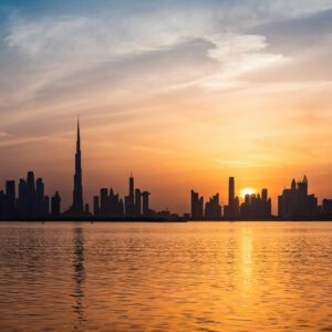 Enchanting view of Dubai's skyscrapers at sunset with the iconic Burj Khalifa outlined against the vivid sky.